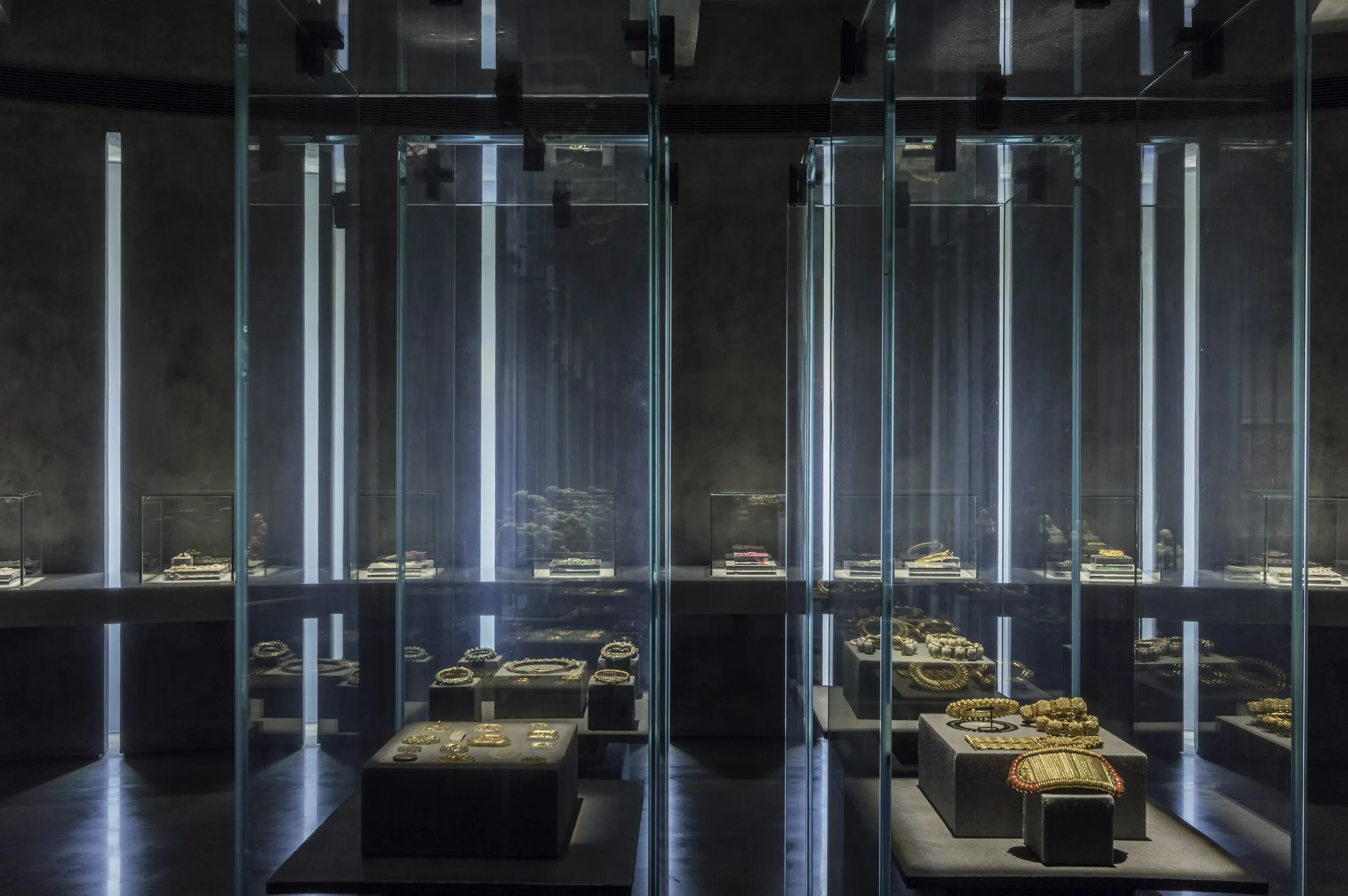 La galerie des bijoux : de hautes vitrines de verre abritant des ornements en or, éclairées de l’intérieur.